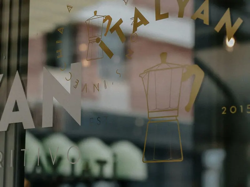 Gold-coloured letters and a drawing on a café window